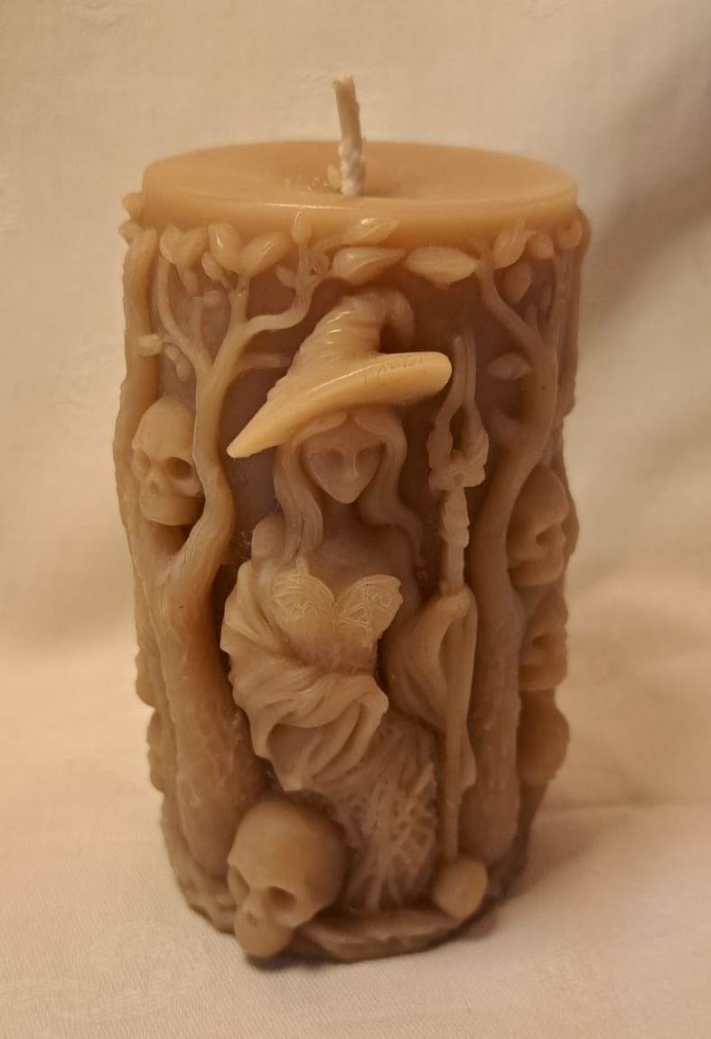 Decorative candle with intricate carvings on a plain background