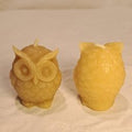 Two owl-shaped candles on a white background showing front and back views