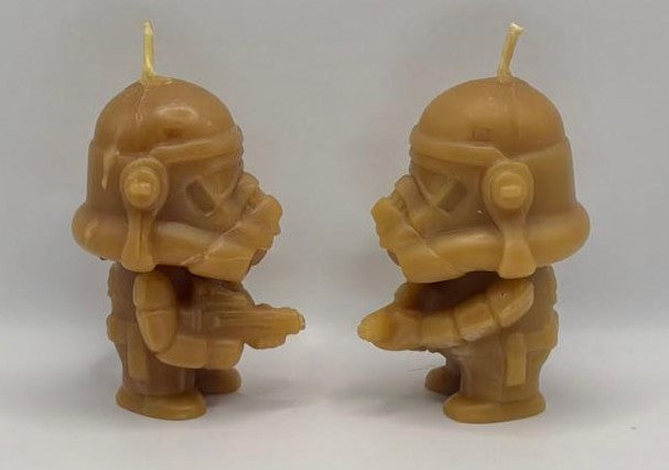 Two Beeswax Trooper candles  facing each other on a plain background