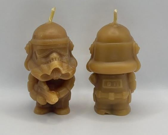 Two beeswax stormtrooper candles on a white background